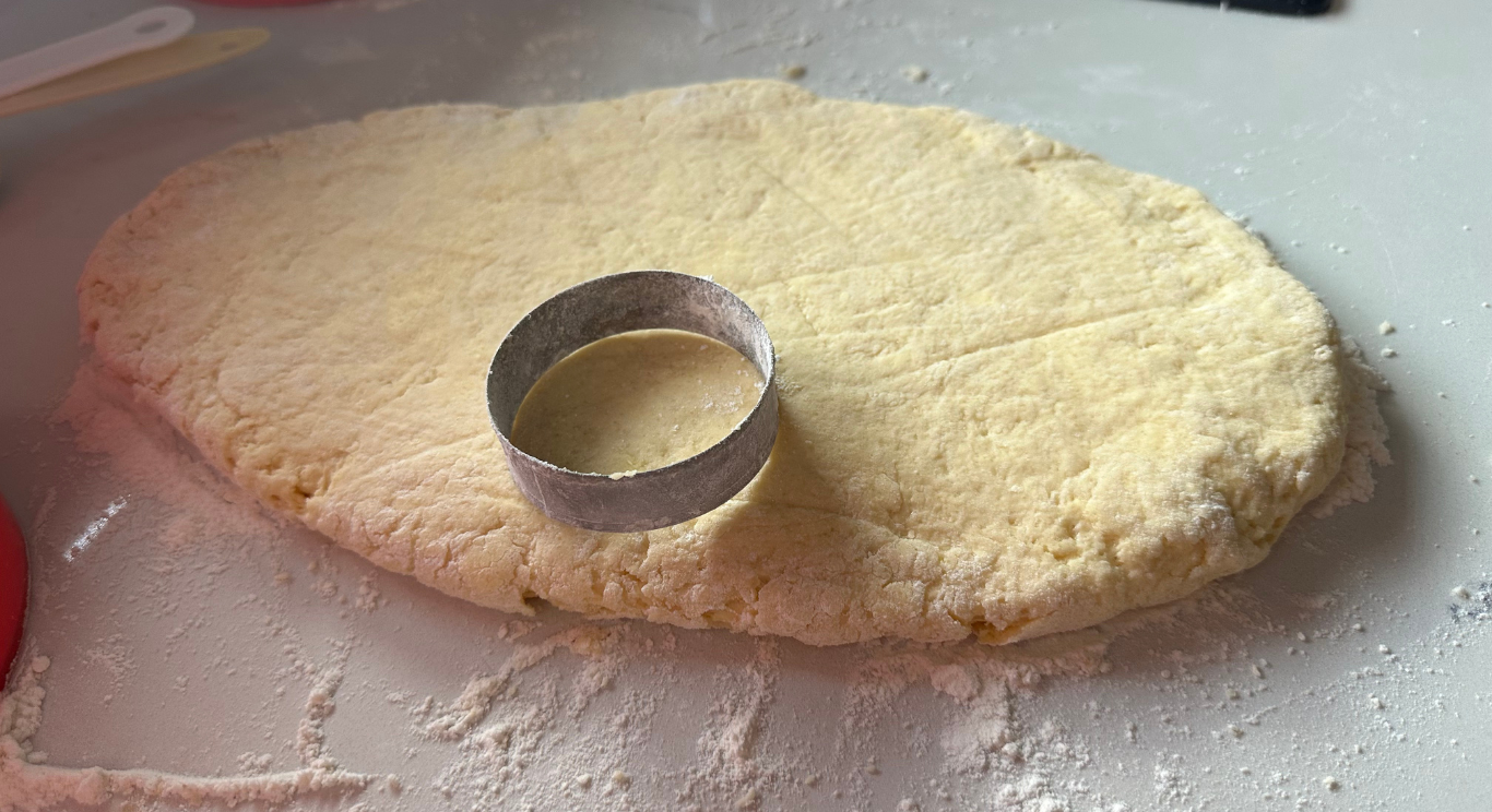 Round scones being cut from rolled dough