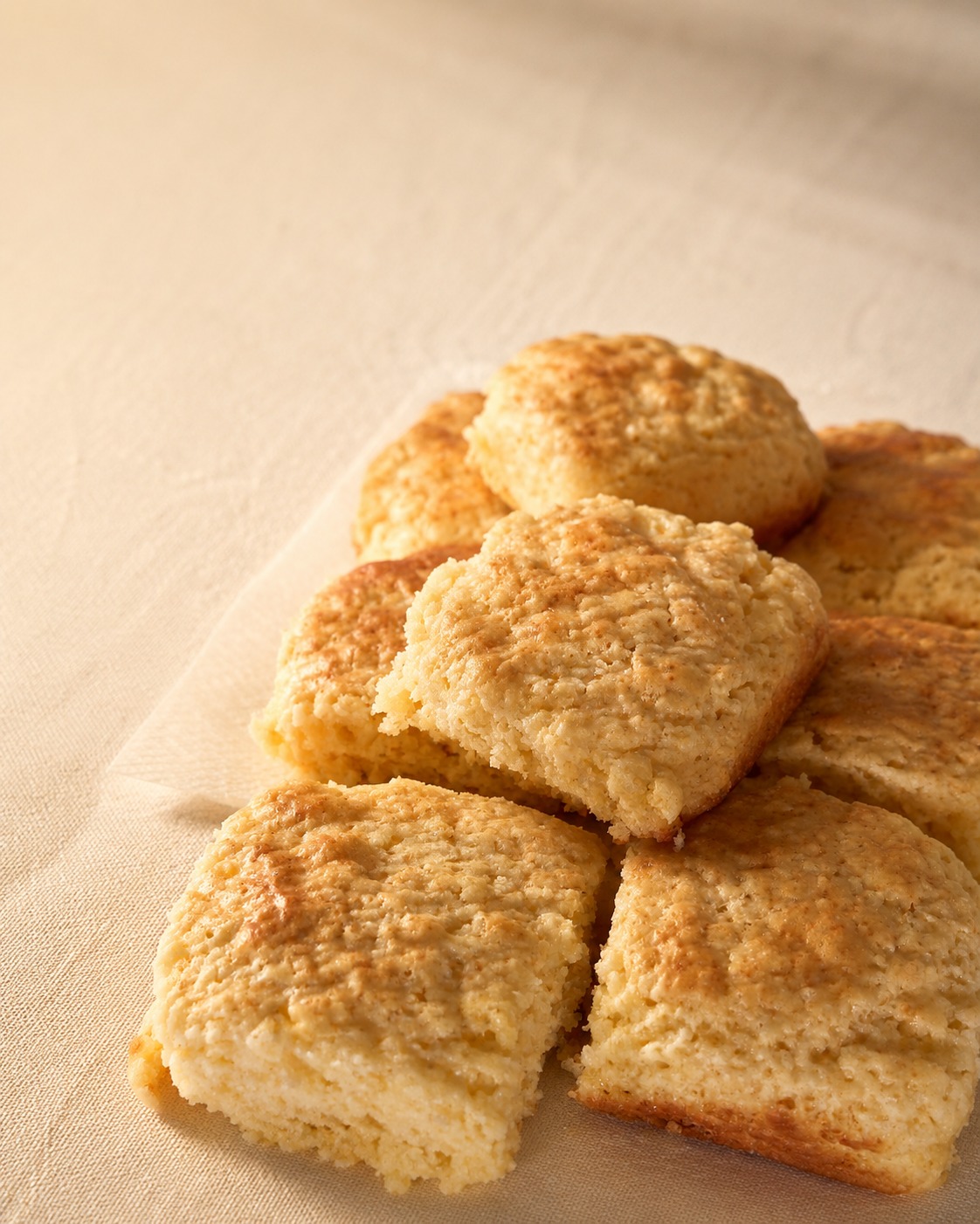 Fresh, soft home-baked scones on a warm linen surface