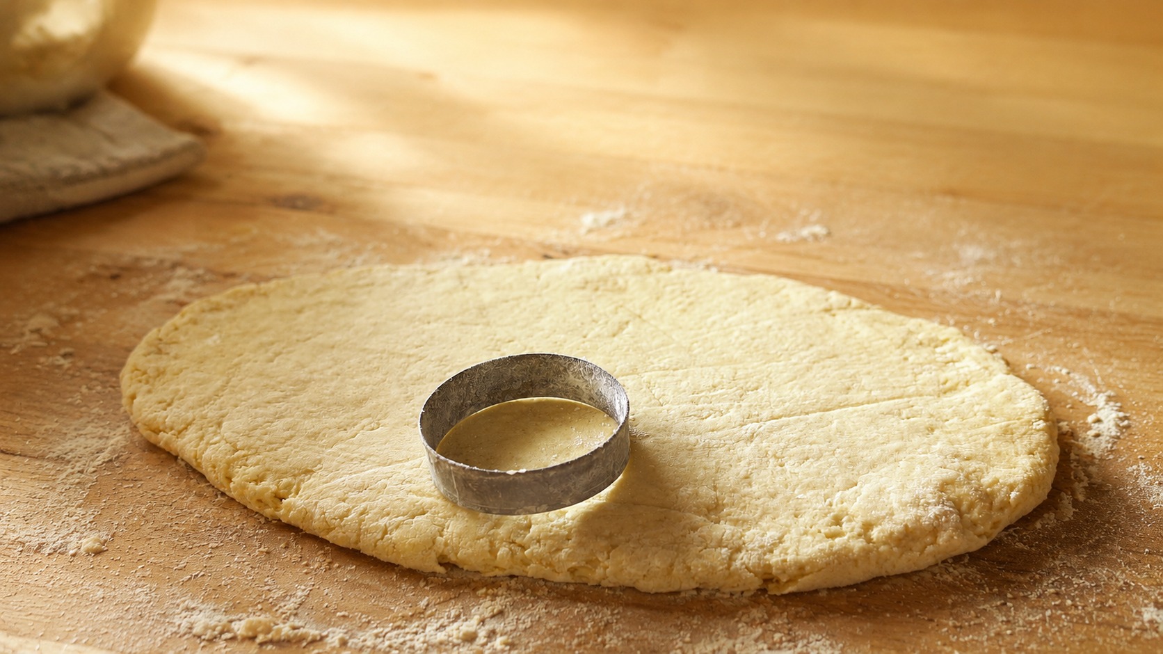 Hands cutting fresh scone dough by hand
